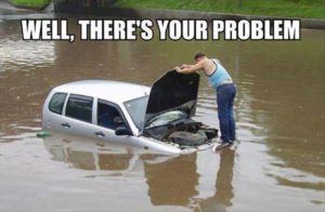 Man looking under the hood of a car sitting in a flood water Caption "Well there's your problem."
